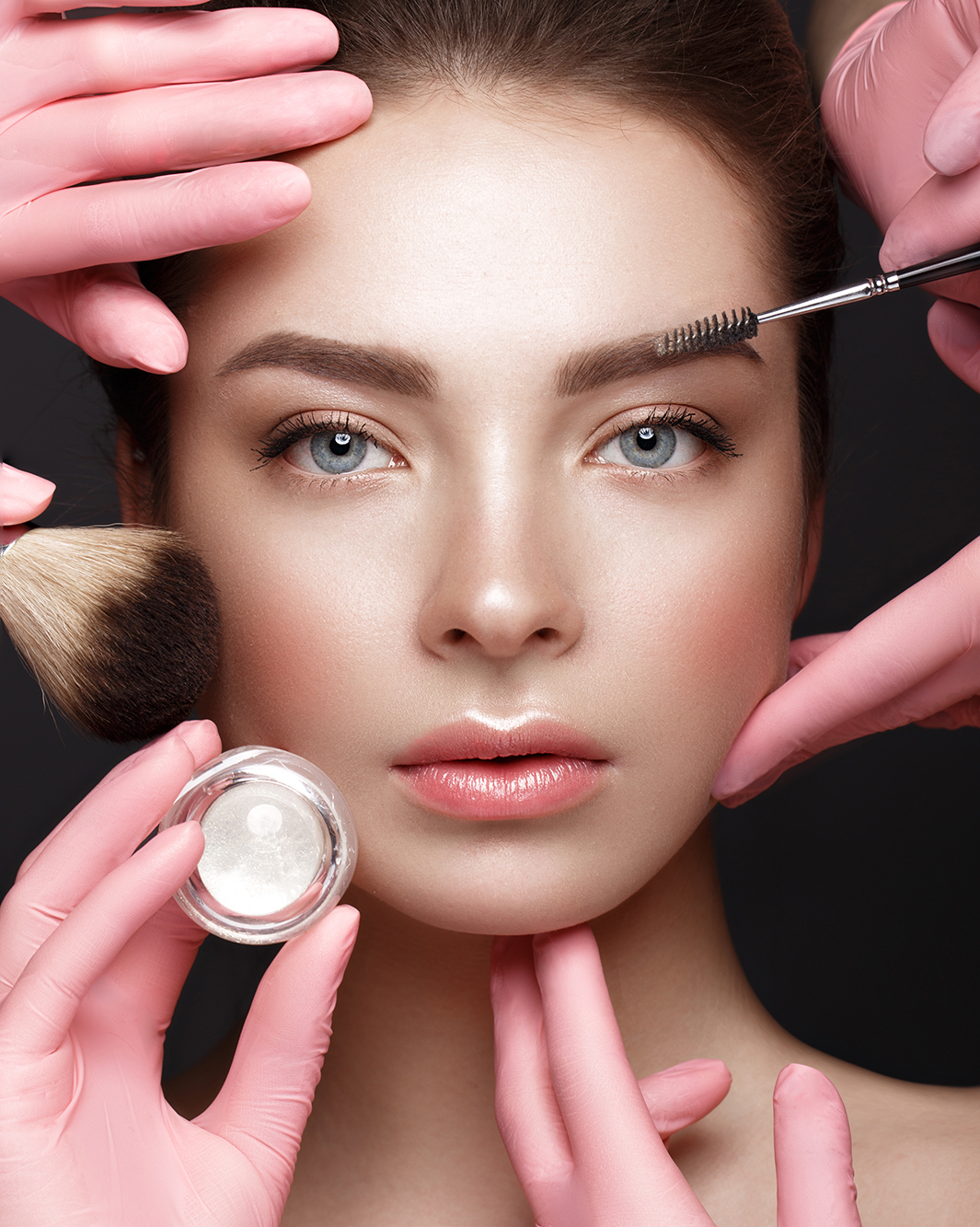 Beautiful young girl with natural nude make-up with cosmetic tools in hands. Beauty face.