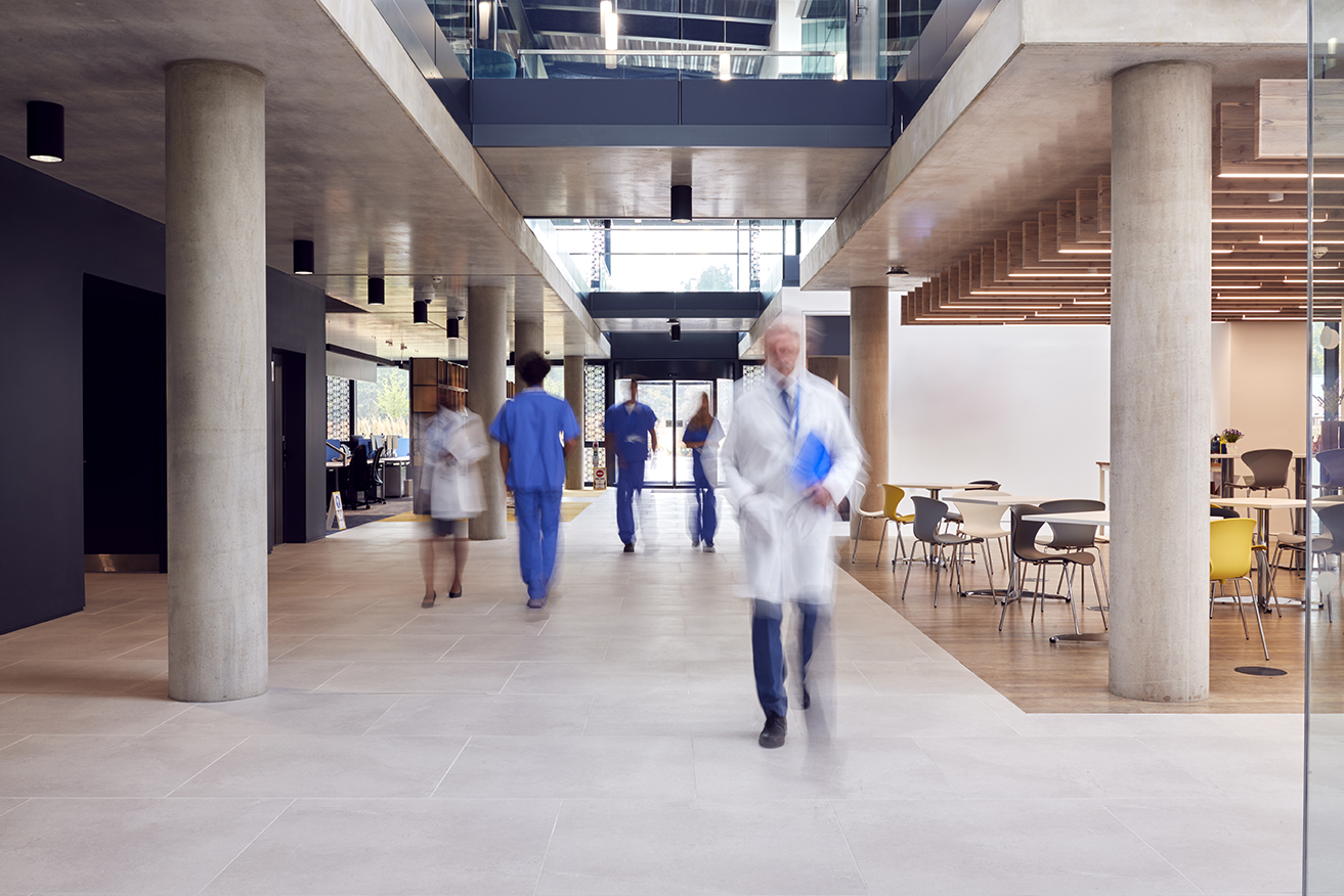 Medical Staff Walking Through Busy Hospital With Motion Blur