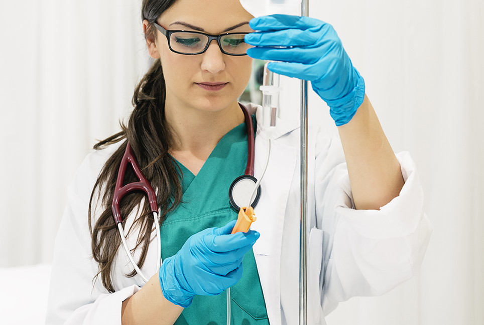 Young woman doctor anesthesiologist dressed in green gown, puts